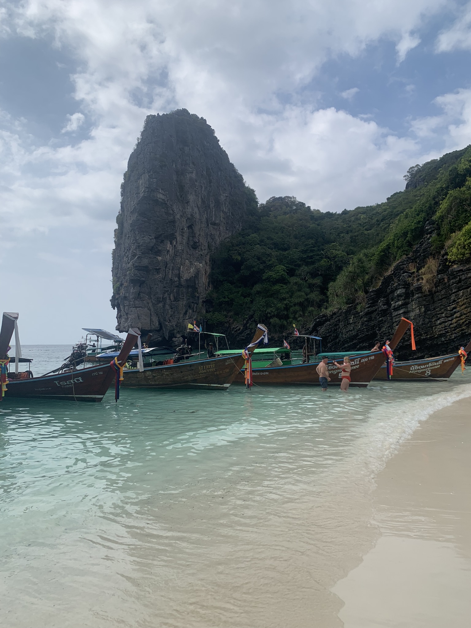 Traditionele Thaise longtailboten aangemeerd bij een indrukwekkende rotspartij op Koh Phi Phi