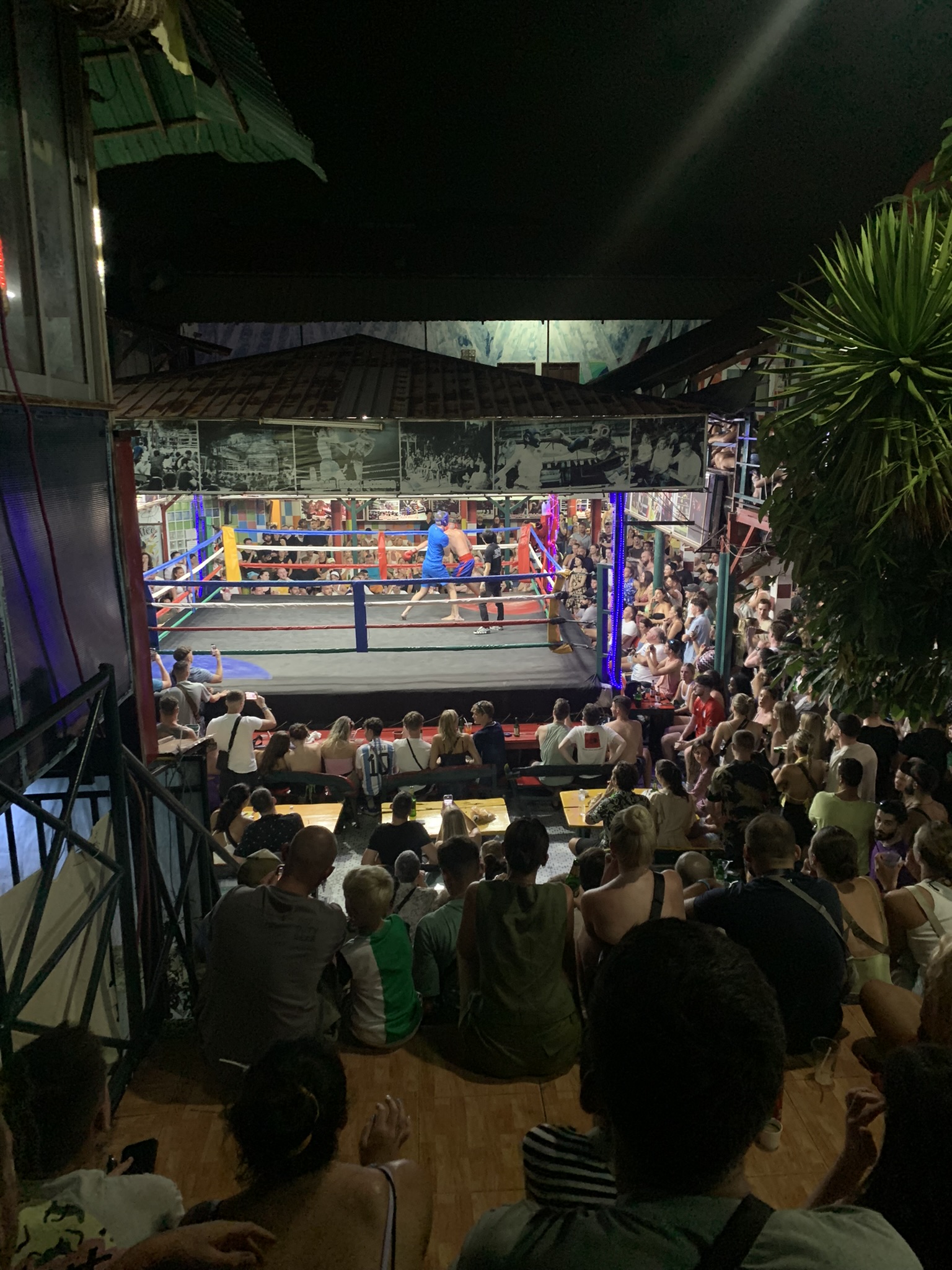 Bezoekers kijken naar een spannende Muay Thai bokswedstrijd in een openlucht arena op Koh Phi Phi
