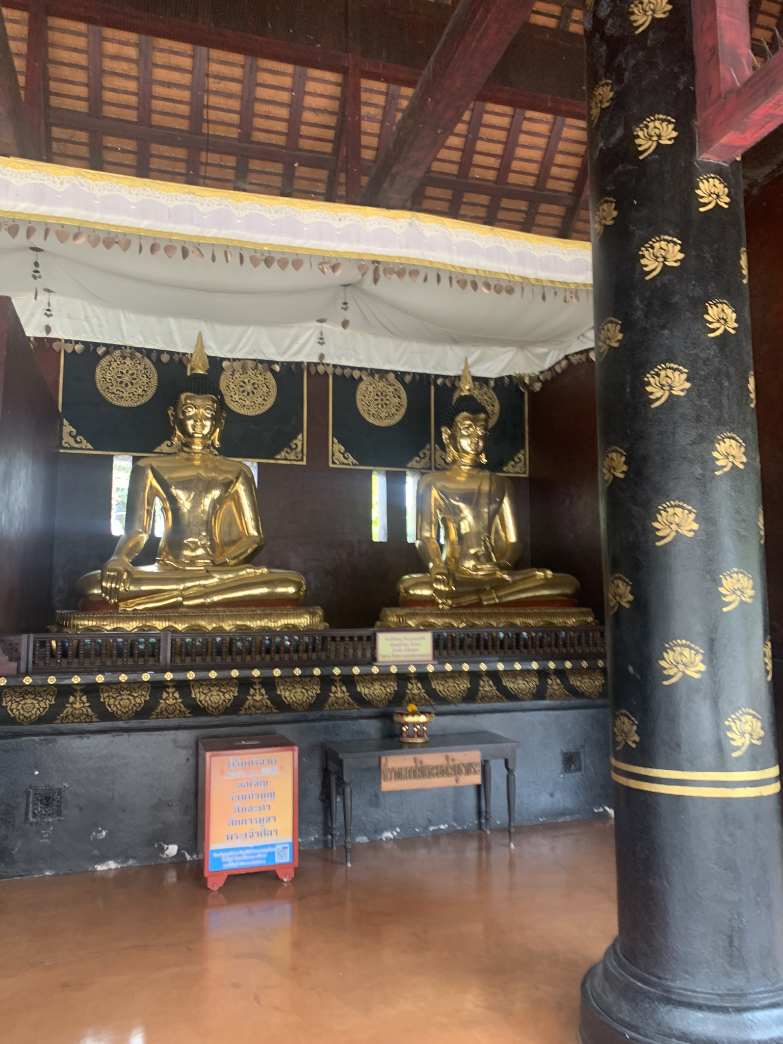 Twee grote zittende gouden Boeddha beelden in een serene Thaise tempel