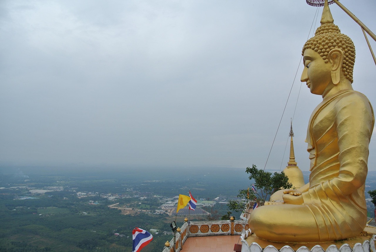 Panoramisch uitzicht over de provincie Krabi vanaf de top van de Tiger Cave Temple (Wat Tham Suea) naast een gouden Boeddha